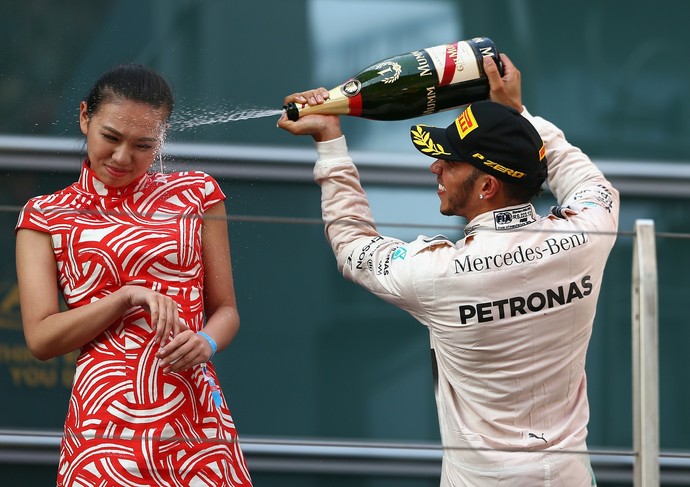 Lewis Hamilton joga champanhe em rosto de mulher no pódio do GP da China (Foto: Getty Images)